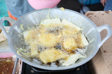 Fried tempeh or Mendoan. Tempeh is being fried in a pan