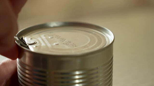 Woman hands opening corn jar. Canned sweet corn in metallic jar