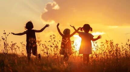 A silhouette of three happy children playing on the field as the sun sets. They are having fun in nature and getting ready to go to school. - obrazy, fototapety, plakaty