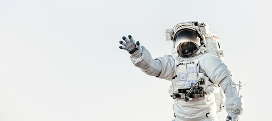 An astronaut reaching out towards the viewer against a clear sky backdrop, symbolizing connection and exploration - obrazy, fototapety, plakaty