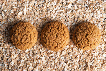 Round brown oatmeal cookies on the oat flakes