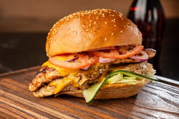 Burger on a wooden board with drink