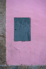 Small blue metallic door on a Pink Wall