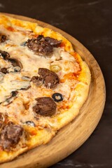 Pizza with meat on wooden background