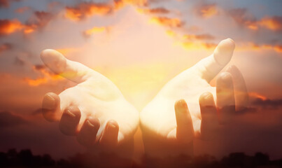 Human hands with open palms reaching from colorful sky, symbolizing connection to heaven and spirituality
