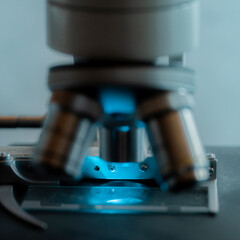 Medical microscope lenses close up, In warm blue lighting