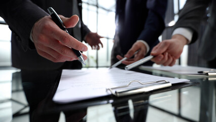 Three men are sitting at a table with a piece of paper in front of them