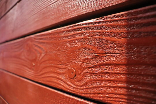 Wooden boards painted red close-up, varnished wood texture.