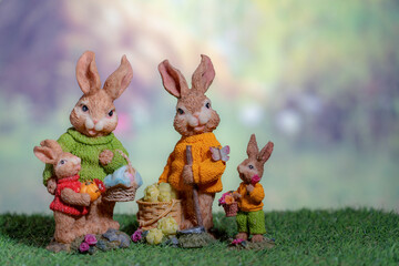 A statue of a rabbit family holding colored Easter eggs. Easter, Pascha or Resurrection Sunday concept