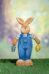 A statue of a rabbit holding colored Easter eggs. Easter, Pascha or Resurrection Sunday concept