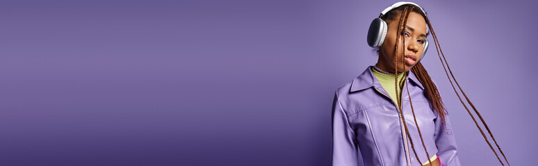 african american girl with dreadlocks and wireless headphones enjoying music on purple, banner