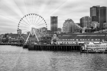 2023-12-31 THE SEATTLE WATER FRONT WITH OFFICE TOWERS THE GREAT WHEEL NEXT TO PIER 54 ON ELLIOTT BAY - obrazy, fototapety, plakaty