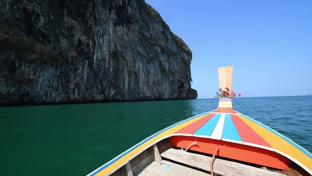 Long tail boat sailing in sea near Mook island with blue sky and mountain in Thailand, trang