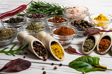Assortment of spices and herbs close-up on wooden background.