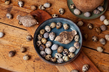 A vibrant display of natural quail eggs, resting on a rustic wooden surface.