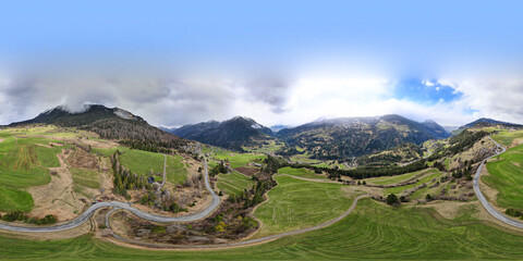 360 degree panorama. Highway between the mountains with the green fields in the region Albula Alvra at the Springtime. Switzerland Alps.