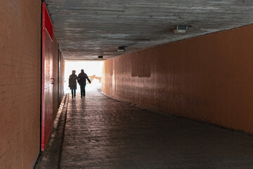 Adult couple crossing a pedestrian underground passageway