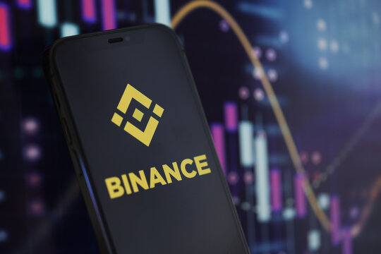 KYIV, UKRAINE - MARCH 15, 2024 Binance logo on iPhone display screen and crypto currency value charts. Cryptocurrency exchange portal