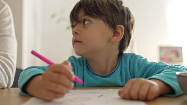 Little Boy Looks At His Mother For Approval During Homework