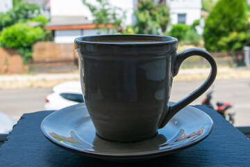 Cup with coffe on the natural stone window sill.