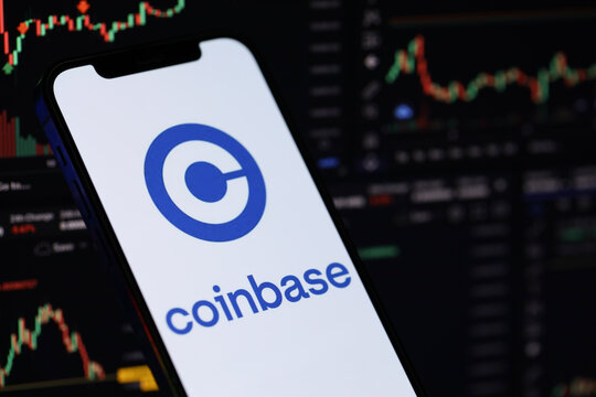 KYIV, UKRAINE - MARCH 15, 2024 Coinbase logo on iPhone display screen and crypto currency value charts. Cryptocurrency exchange portal