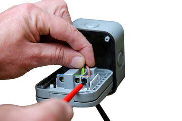 Man wiring an outdoor electric socket using an electrical screwdriver. Isolated on a white background