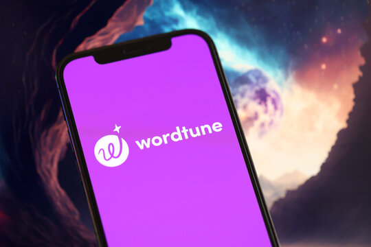 KYIV, UKRAINE - MARCH 17, 2024 Wordtune logo on iPhone display screen with background of artificial intelligence futuristic ai generated image close up