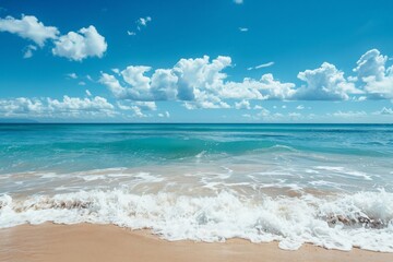 Sandy beach with gentle waves softly rolling onto the shore under a clear blue sky on a peaceful day.