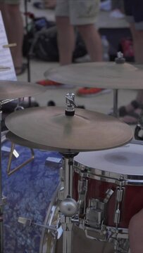 Detail oriented vertical video of the drummer's musical equipment. Playing the drums, a musical instrument rehearsal. Drum preparation for the concert. Tuning of the musical instrument. Outdoor concer