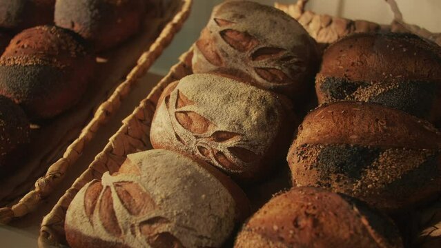 Fresh artesian bread on bakery shop close-up. Bread with black poppy garnish on top and white flour on top. Artisan bread is making by skill bakers using natural and