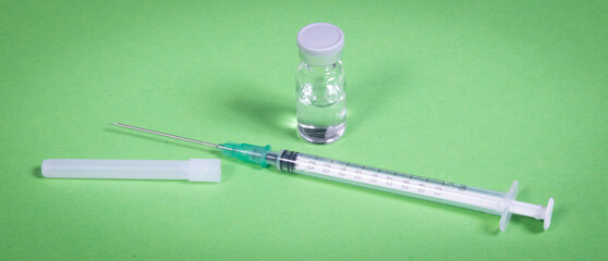 Syringe injection or medical needle isolated on green