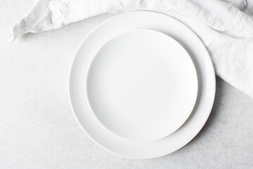 Top view of white ceramic plates on a marble table, white ceramic minimalist white plate