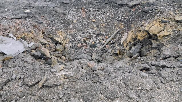 A crater from a rocket attack. Consequences of a rocket attack.