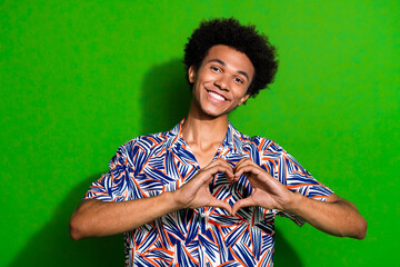 Portrait of cute young boyfriend wearing jamaican shirt showing love symbol as feedback for you...