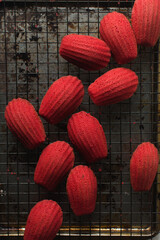 Red velvet madeleines on a on a cooling rack, overhead view of red madeleines cake or cookies on...