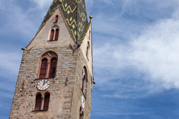 The multi colored bell tower of the church of Villandro in Val Isarco, Italy