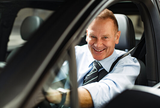 Mature businessman driving to work in his car