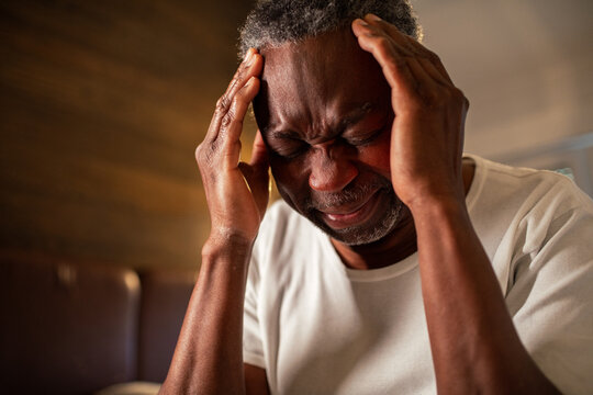 Senior man with a headache at home