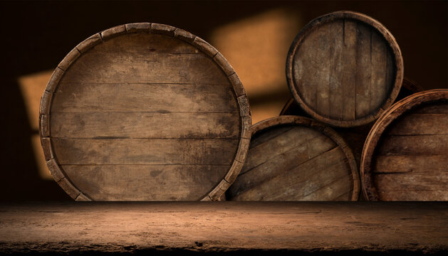 Three wooden barrels stacked on top of each other on a wooden table, creating a rustic display. The closeup shot highlights the wood grain and metal accents
