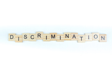 discrimination- word composed fromwooden blocks letters on White background, copy space for ad text. - obrazy, fototapety, plakaty