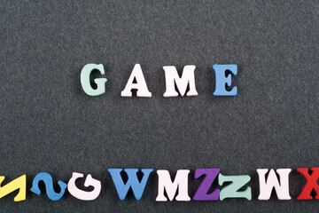 Fototapeta premium GAME word on black board background composed from colorful abc alphabet block wooden letters, copy space for ad text. Learning english concept.