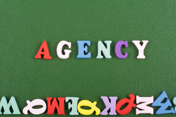 AGENCY word on green background composed from colorful abc alphabet block wooden letters, copy...