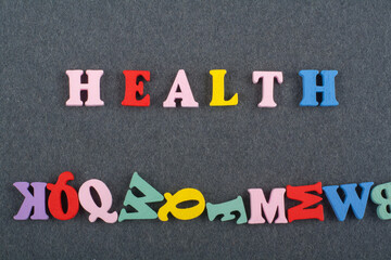 HEALTH word on black board background composed from colorful abc alphabet block wooden letters,...