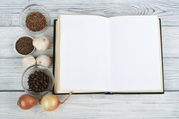 Recipe cook blank book on wooden background, spoon, rolling pin, checkered tablecloth. Top view