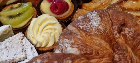 Close-up of a tempting assortment of gourmet pastries including raspberry tart. Custard croissant....