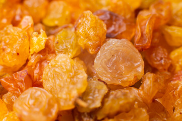 Background of a large number of dried yellow golden grapes. Raisin. Vegetarian diet