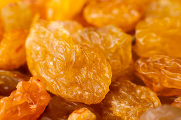 Background of a large number of dried yellow golden grapes. Raisin. Vegetarian diet