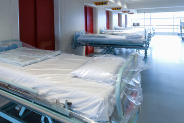 Fototapeta na wymiar Clean hospital beds covered with film, ready for new patients.