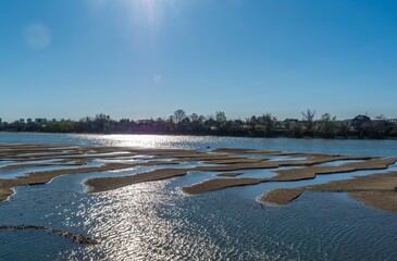 reflection of the sun in the water of the shallowed Kuban River near the city of Krasnodar in early...