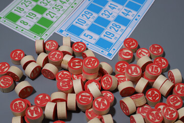 lotto game. on a gray background, multi-colored cards with numbers and wooden barrels with numbers